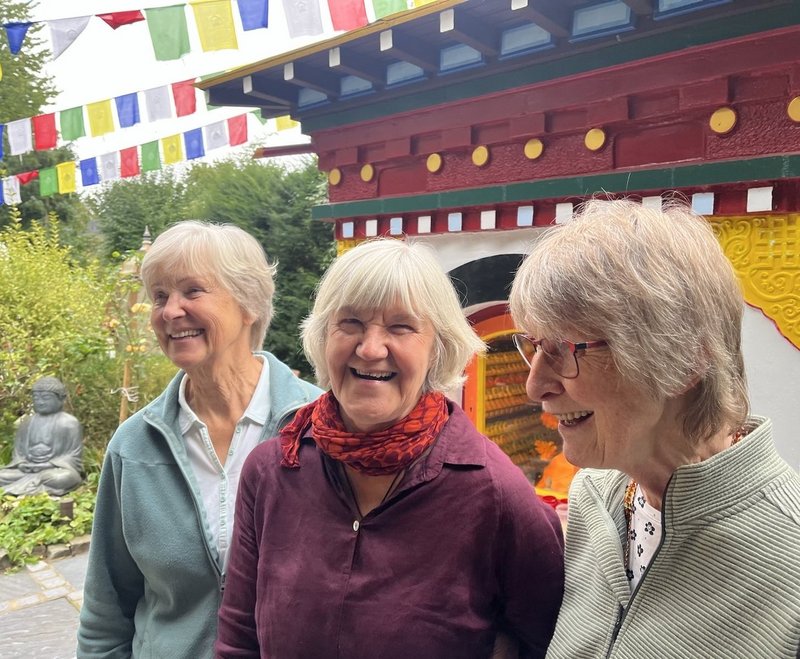 Drei Frauen vor einem bunten  Schrein